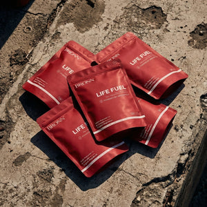 Red 'LIFE FUEL' packets on a textured stone surface