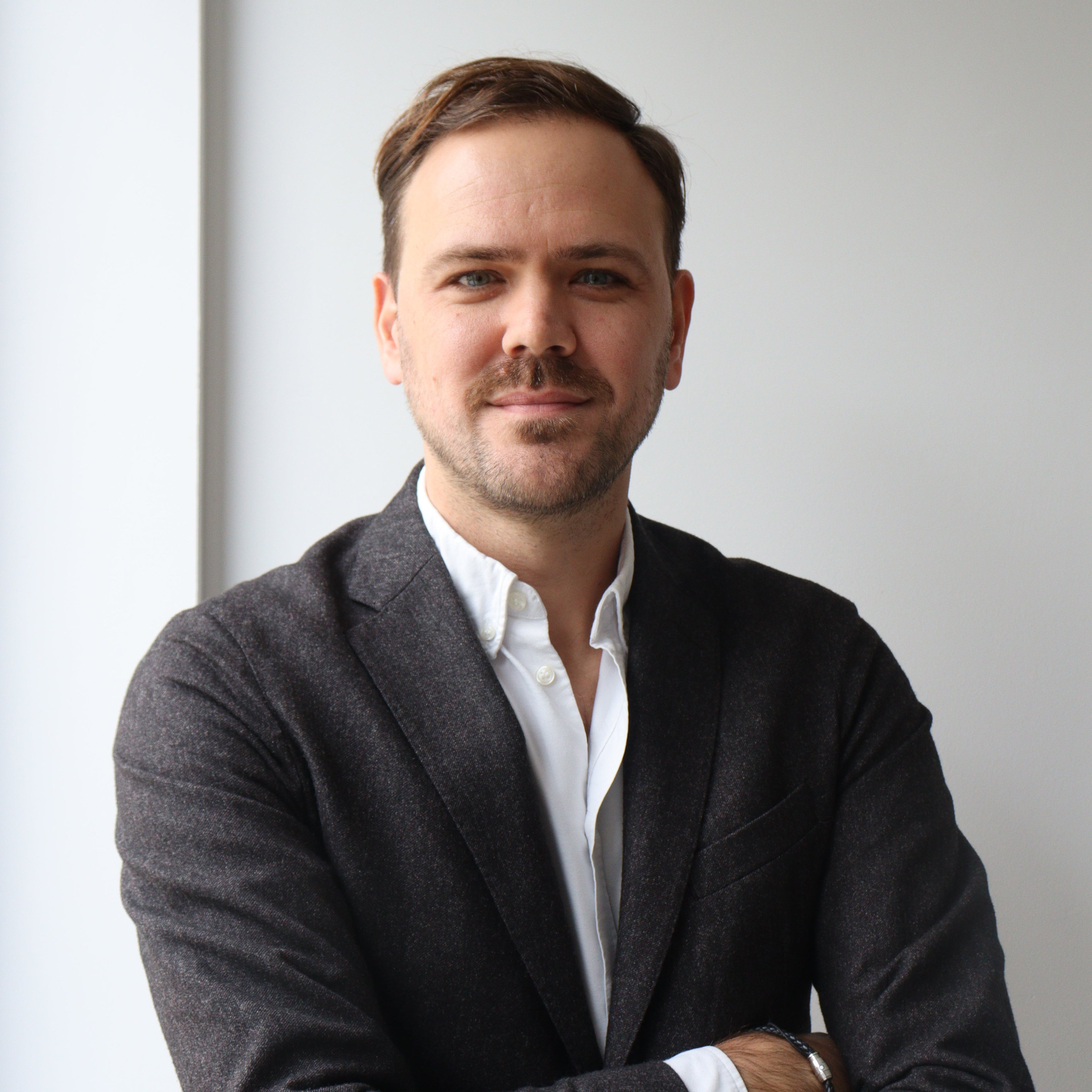 Man in a suit against a plain background
