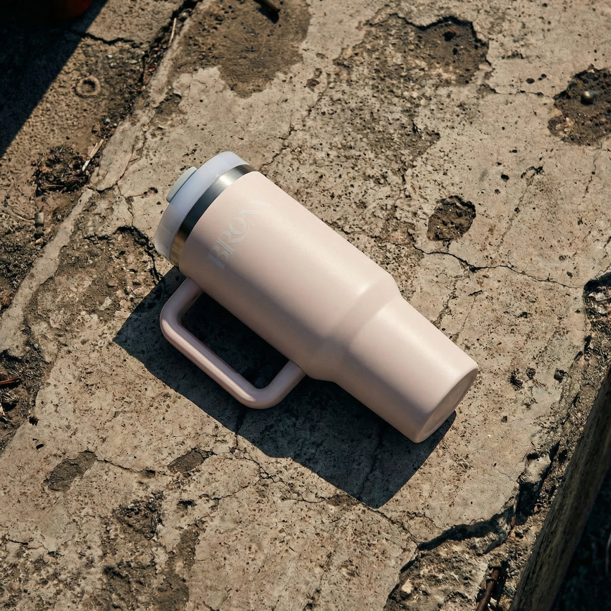 White tumbler with a black interior on a textured concrete surface