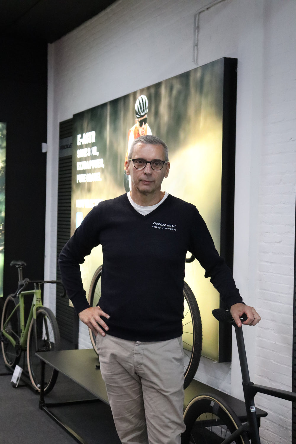 Person standing next to a large printed photo of a person with a crown.