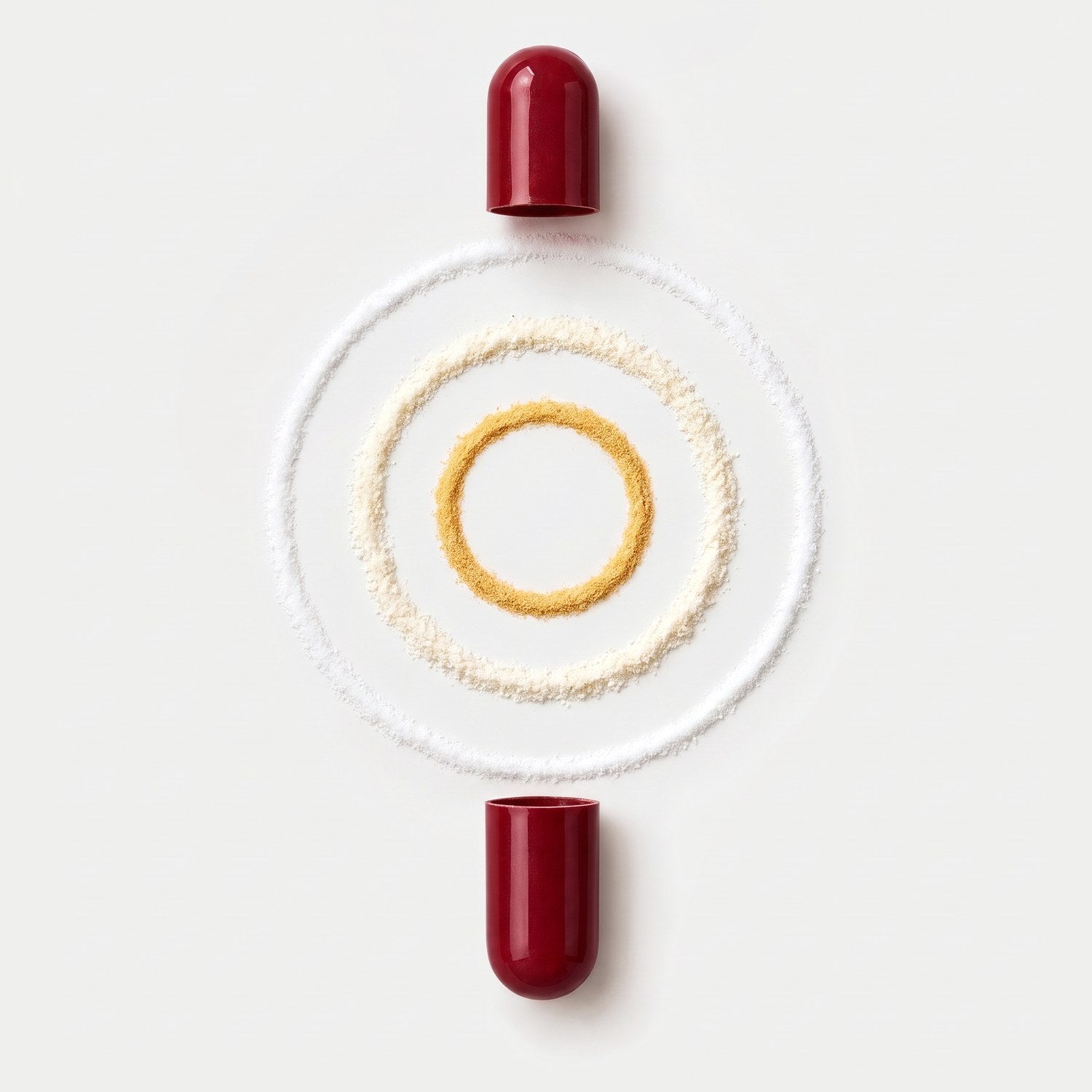 An opened red LIFE FUEL&trade; capsule with three rings of powder: NR (white), magnesium bisglycinate (cream) and B vitamins (yellow)